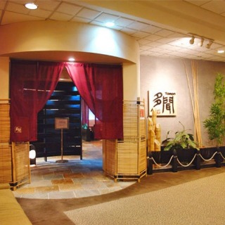 Tranquil entrance to a Japanese restaurant with traditional decor area, seen from the left side.