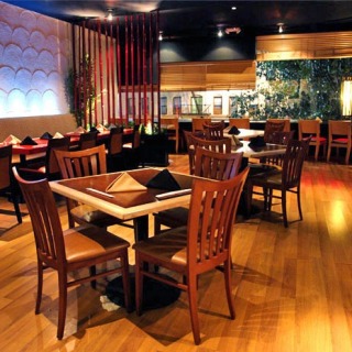 Interior of a restaurant with wooden floors and tables.
