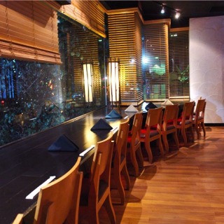 A long wooden table surrounded by chairs, with a view of a window.