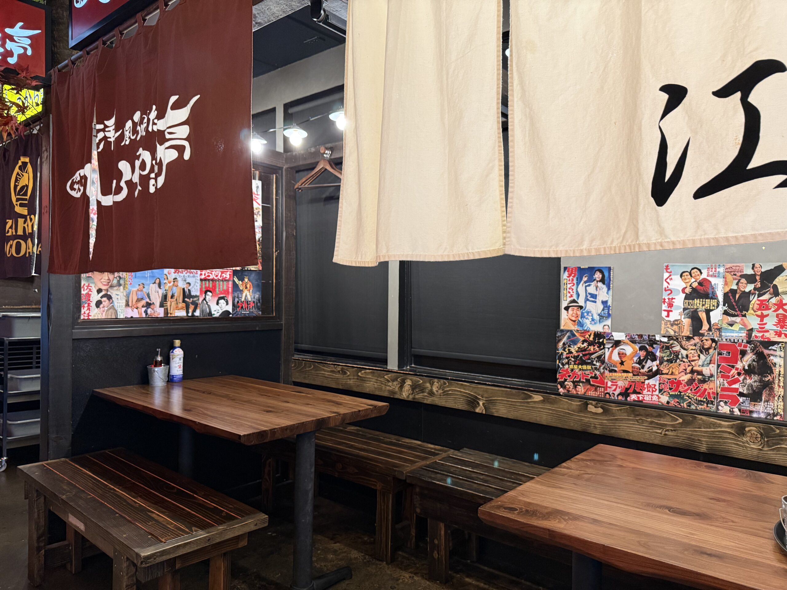 Dining area at Daikokuya Torrance decorated with vintage Japanese movie posters and wooden bench seating.