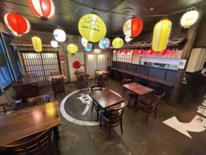 Interior dining area of Daikokuya Torrance decorated with colorful Japanese paper lanterns and wooden tables.