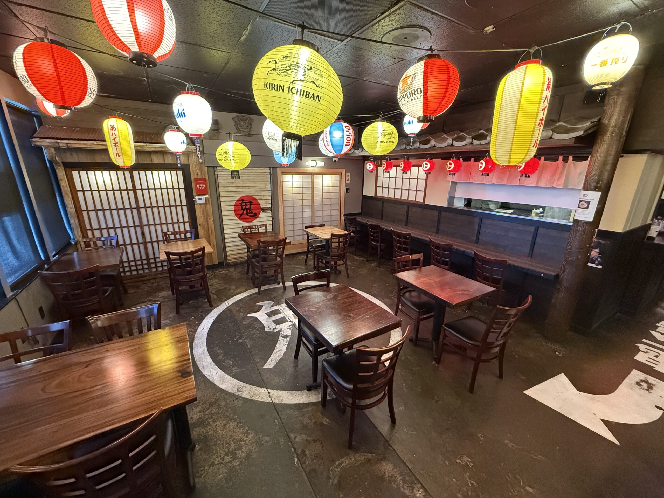 Interior dining area of Daikokuya Torrance decorated with colorful Japanese paper lanterns and wooden tables.