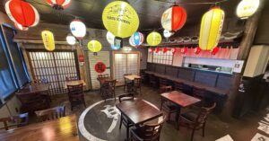 Interior dining area of Daikokuya Torrance decorated with colorful Japanese paper lanterns and wooden tables.