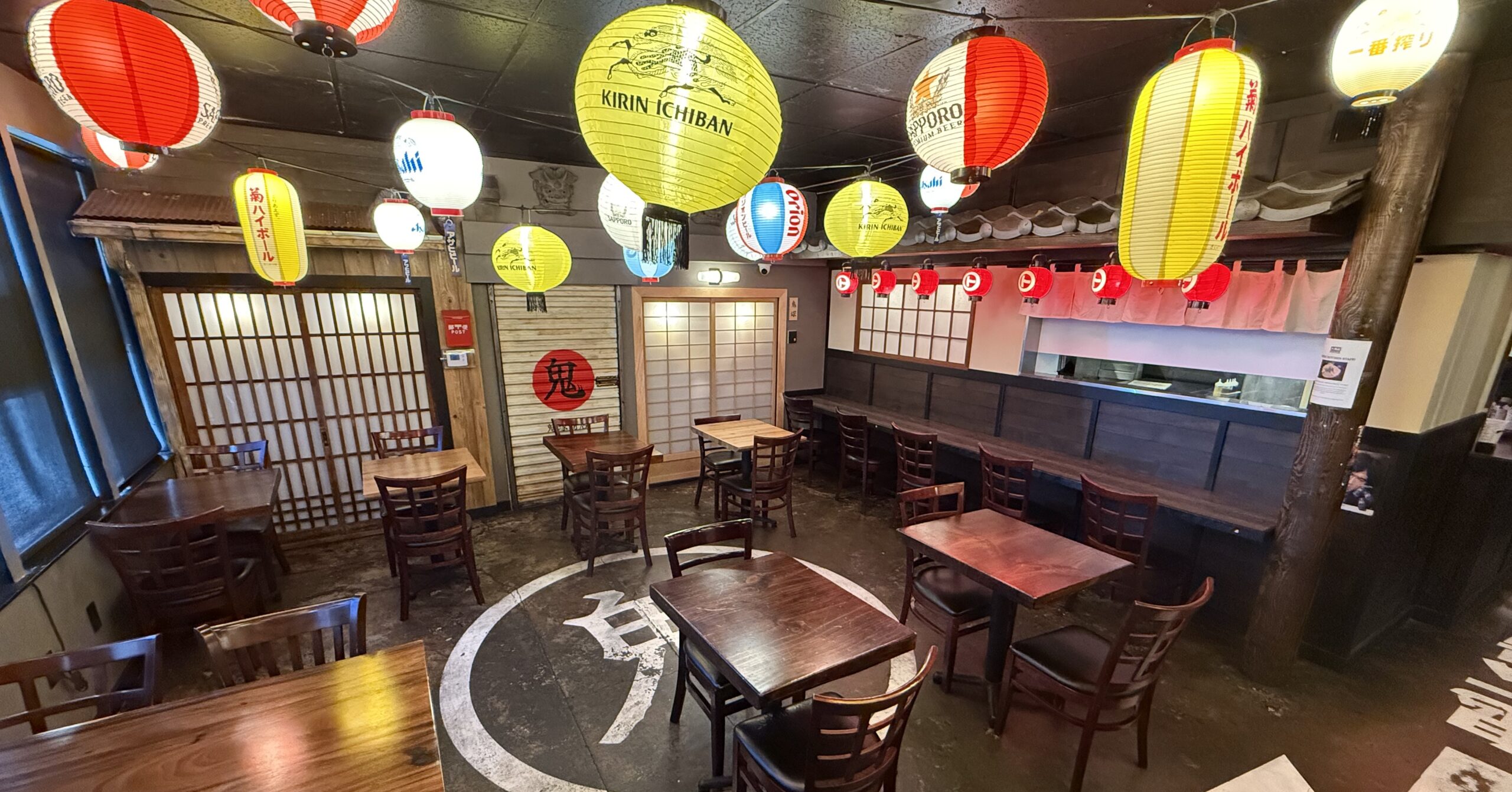 Interior dining area of Daikokuya Torrance decorated with colorful Japanese paper lanterns and wooden tables.